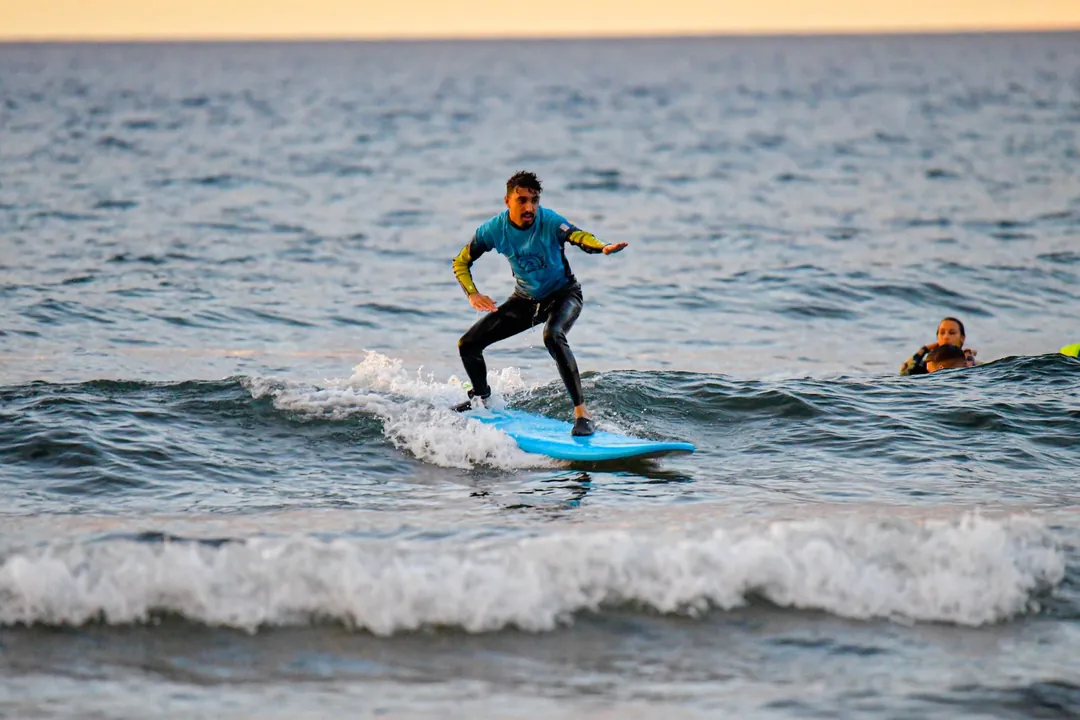 Surf al atardecer en Tenerife Surfista con la lycra de Single Fin cogiendo una ola al atardecer en Tenerife
