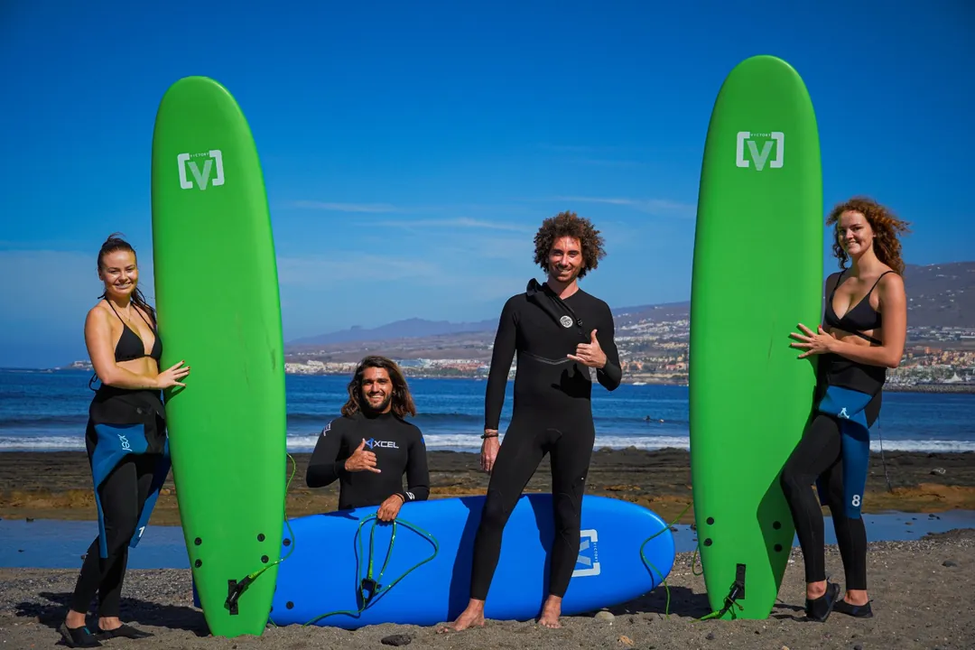 Equipo de Single Fin con alumnas y sus tablas de surf en la playa, en el sur de Tenerife