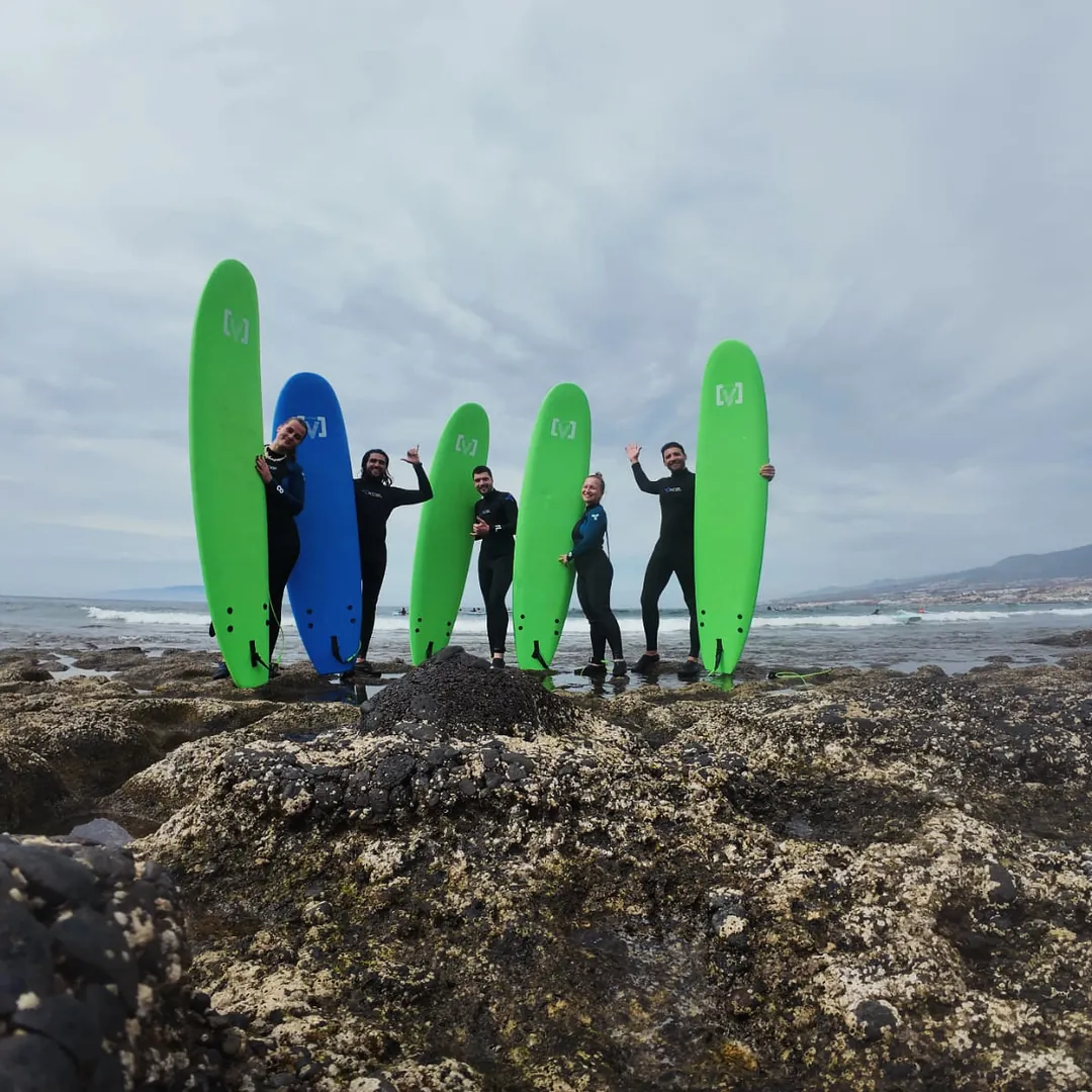 Surf Camp en Tenerife Grupo de surfistas de Single Fin posando con sus tablas sobre las rocas volcánicas de la costa de Tenerife