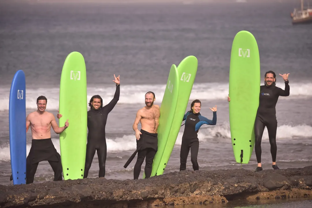 Grupo de surf de Single Fin Grupo de alumnos de Single Fin celebrando con sus tablas de surf junto al mar en Tenerife